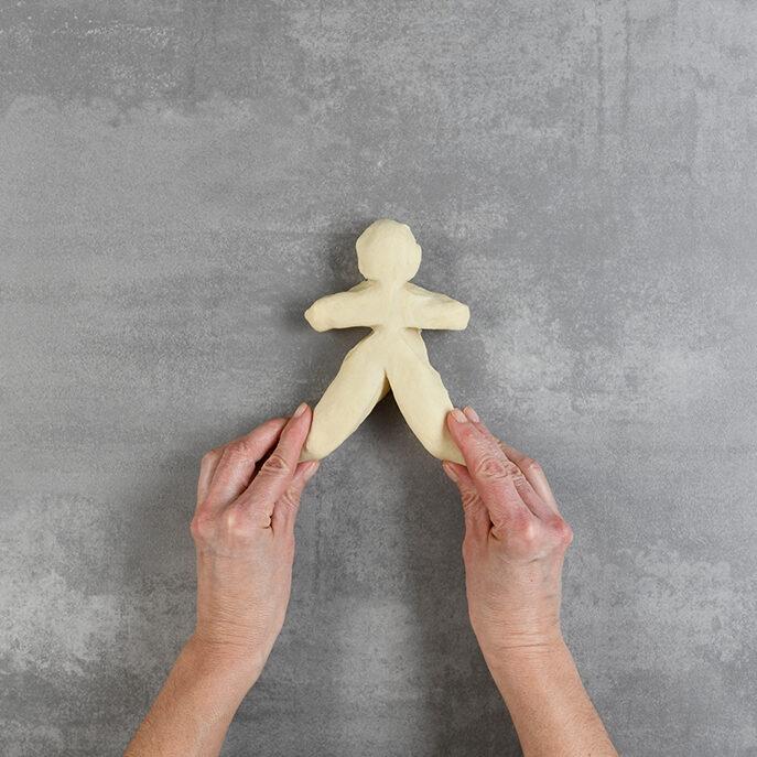 Grittibänz-Teigstück als Figur auf Arbeitsplatte