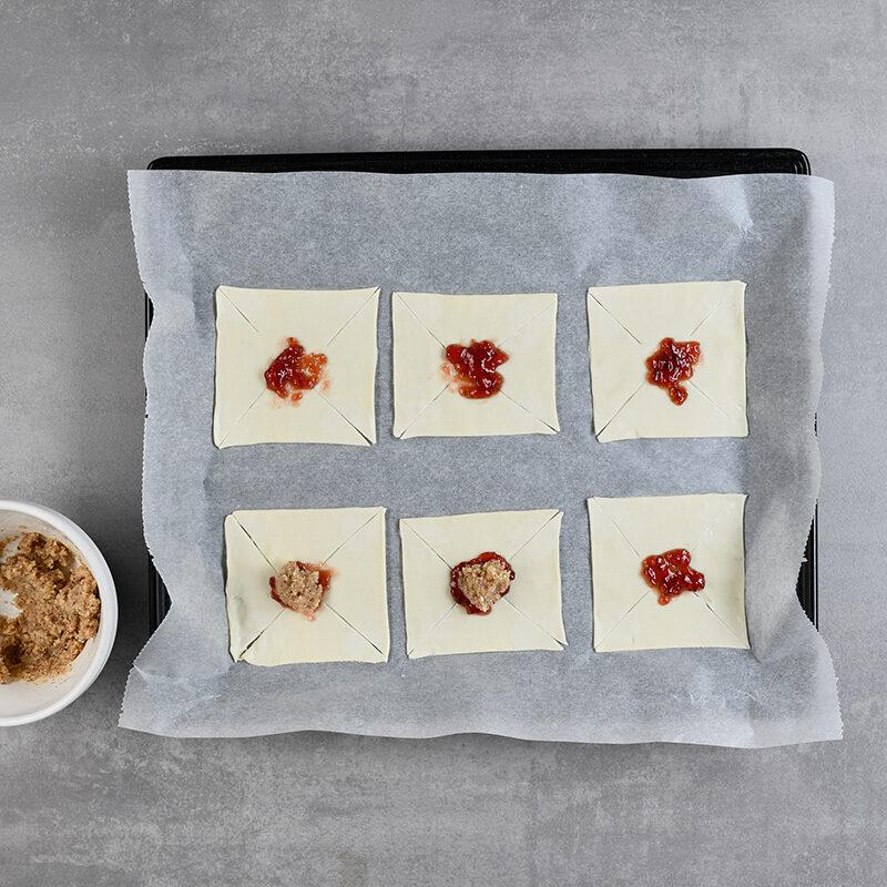 Blätterteigstücke mit Füllung auf Backblech