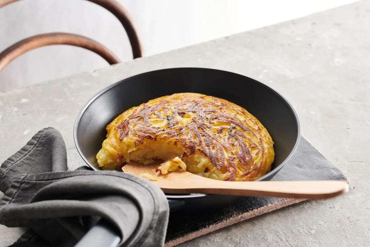 Rohe Kartoffelrösti aus der Kategorie Kartoffeln &amp; Süsskartoffeln. Zubereitungsmethode Braten. Das fertige Gericht schön angerichtet und fotografiert aus Vogelperspektive (Food Fotografie). Serviervorschlag, Original Tiptopf Rezept, aus dem bekanntesten Kochbuch der Schweiz