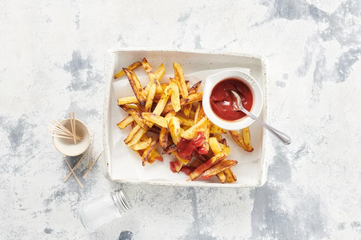 Ofenfrites aus der Kategorie Kartoffeln &amp; Süsskartoffeln. Zubereitungsmethode Backen. Das fertige Gericht schön angerichtet und fotografiert aus Vogelperspektive (Food Fotografie). Serviervorschlag, Original Tiptopf Rezept, aus dem bekanntesten Kochbuch der Schweiz