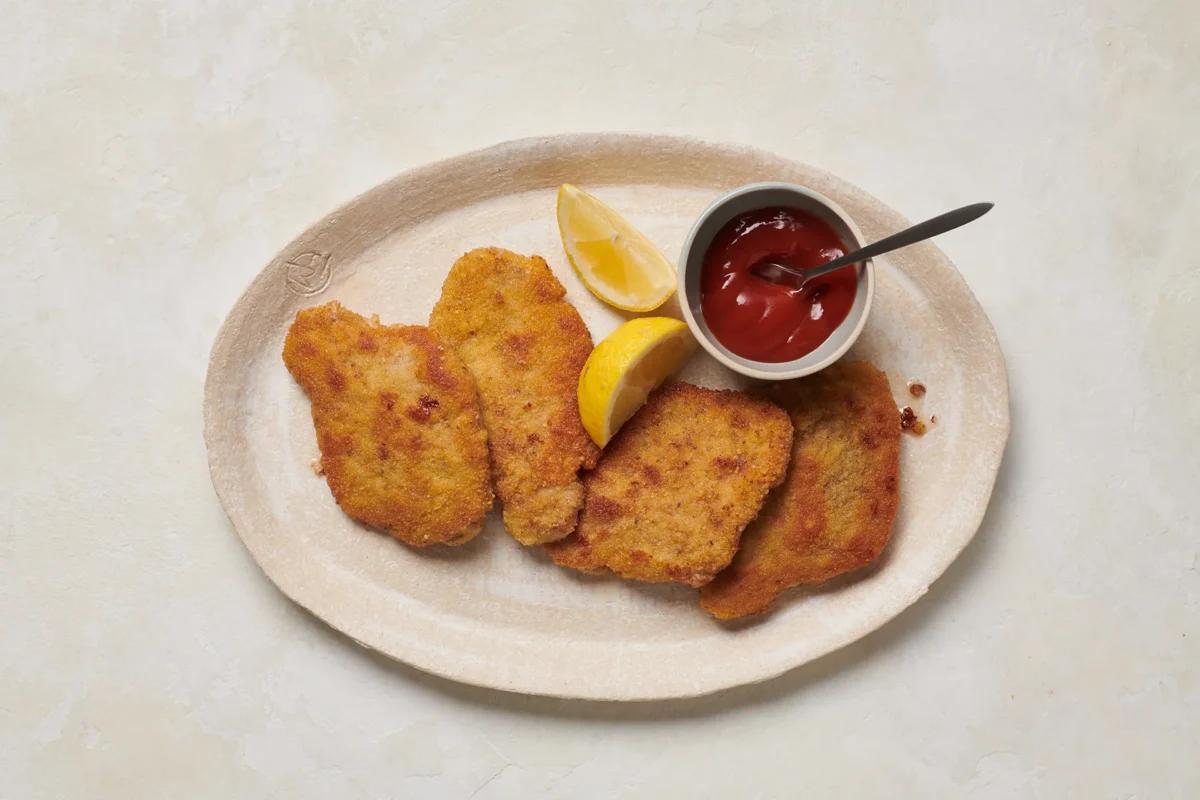 Panierte Plätzli aus der Kategorie Fleisch &amp; Fisch. Zubereitungsmethode Braten. Das fertige Gericht schön angerichtet und fotografiert aus Vogelperspektive (Food Fotografie). Serviervorschlag, Original Tiptopf Rezept, aus dem bekanntesten Kochbuch der Schweiz