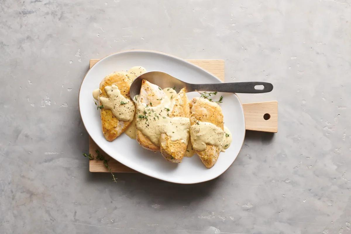 Poulet an Senfrahmsauce aus der Kategorie Fleisch &amp; Fisch. Zubereitungsmethode Braten. Das fertige Gericht schön angerichtet und fotografiert aus Vogelperspektive (Food Fotografie). Serviervorschlag, Original Tiptopf Rezept, aus dem bekanntesten Kochbuch der Schweiz