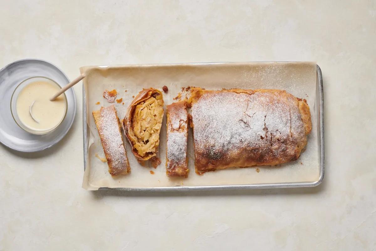 Apfelstrudel aus der Kategorie Gebäck süss. Zubereitungsmethode Angerührter Teig. Das fertige Gericht schön angerichtet und fotografiert aus Vogelperspektive (Food Fotografie). Serviervorschlag, Original Tiptopf Rezept, aus dem bekanntesten Kochbuch der Schweiz