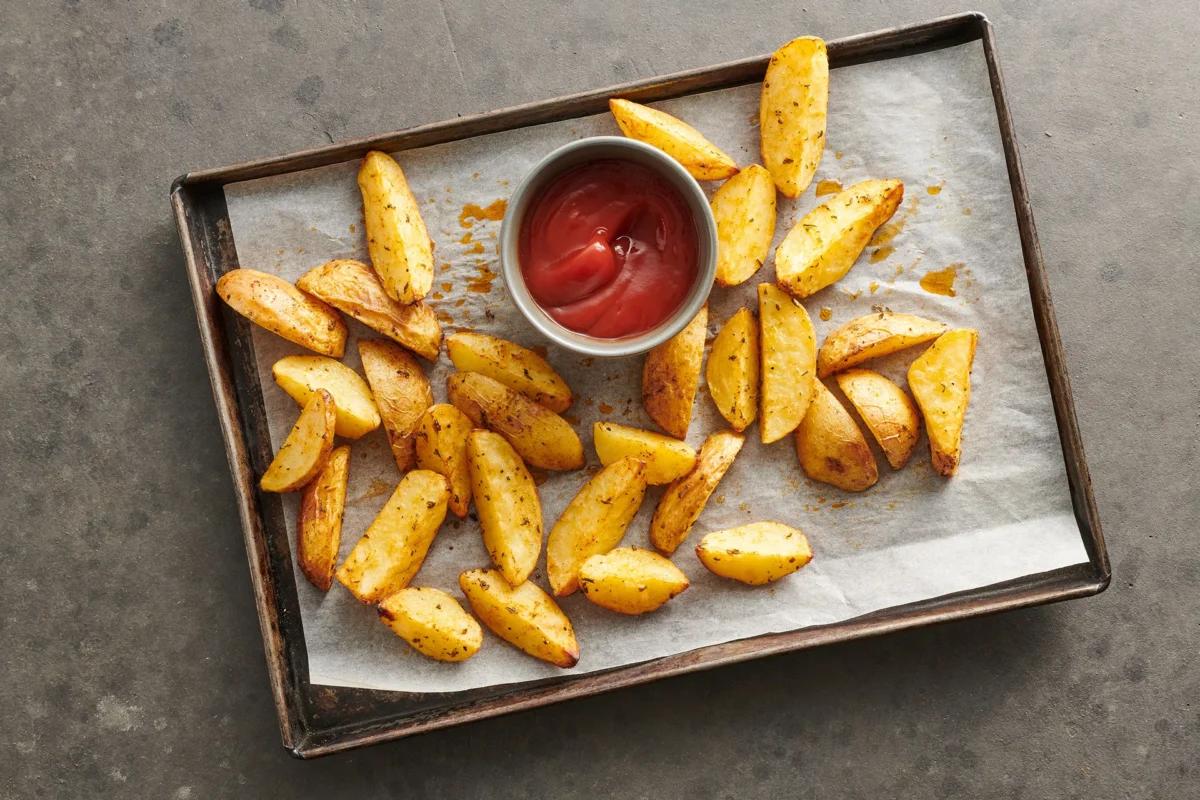 Kartoffelwedges  aus der Kategorie Kartoffeln &amp; Süsskartoffeln. Zubereitungsmethode Backen. Das fertige Gericht schön angerichtet und fotografiert aus Vogelperspektive (Food Fotografie). Serviervorschlag, Original Tiptopf Rezept, aus dem bekanntesten Kochbuch der Schweiz