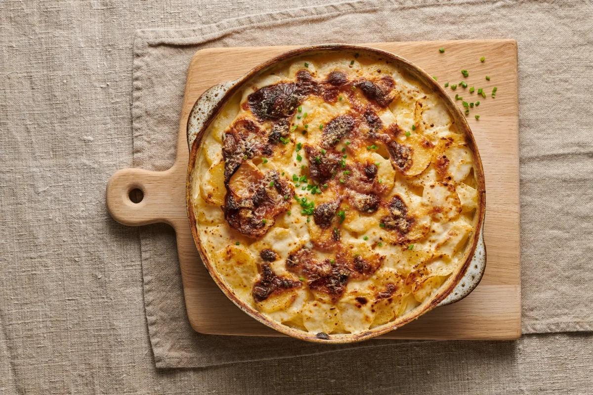 Kartoffelgratin. Das fertige Gericht schön angerichtet und fotografiert aus Vogelperspektive (Food Fotografie). Serviervorschlag, Original Tiptopf Rezept, aus dem bekanntesten Kochbuch der Schweiz