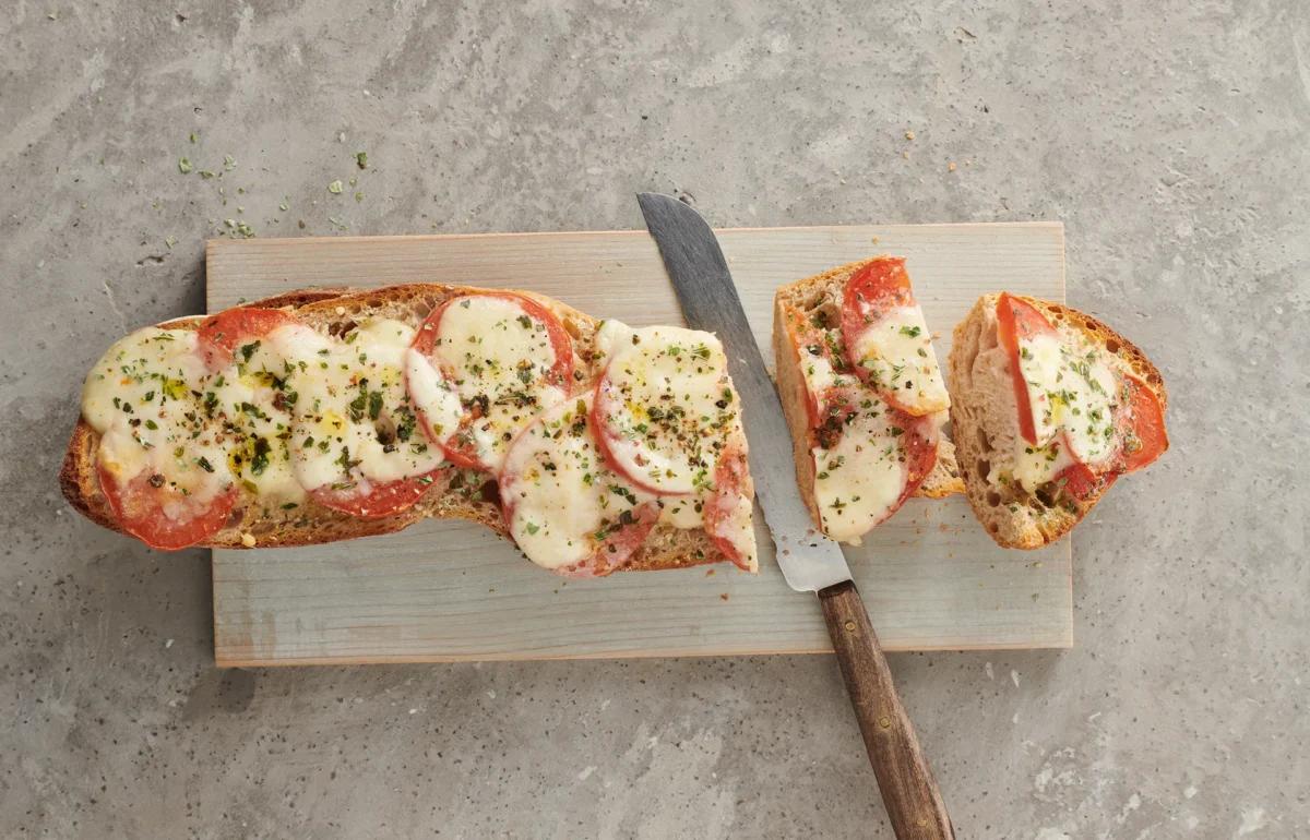 Pizzabaguette aus der Kategorie Snacks &amp; Fingerfood (2). Zubereitungsmethode Backen. Das fertige Gericht schön angerichtet und fotografiert aus Vogelperspektive (Food Fotografie). Serviervorschlag, Original Tiptopf Rezept, aus dem bekanntesten Kochbuch der Schweiz