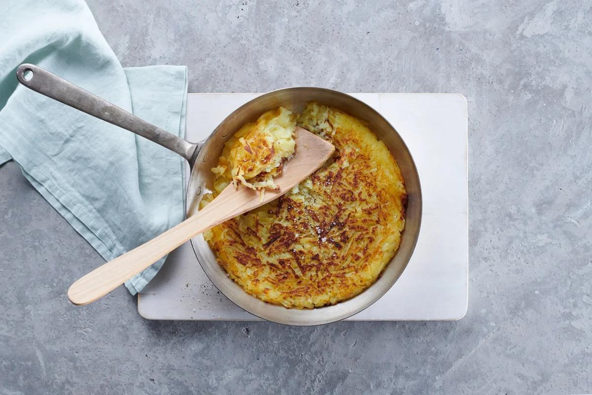 Rösti aus gekochten Kartoffeln aus der Kategorie Reste verwerten. Das fertige Gericht schön angerichtet und fotografiert aus Vogelperspektive (Food Fotografie). Serviervorschlag, Original Tiptopf Rezept, aus dem bekanntesten Kochbuch der Schweiz