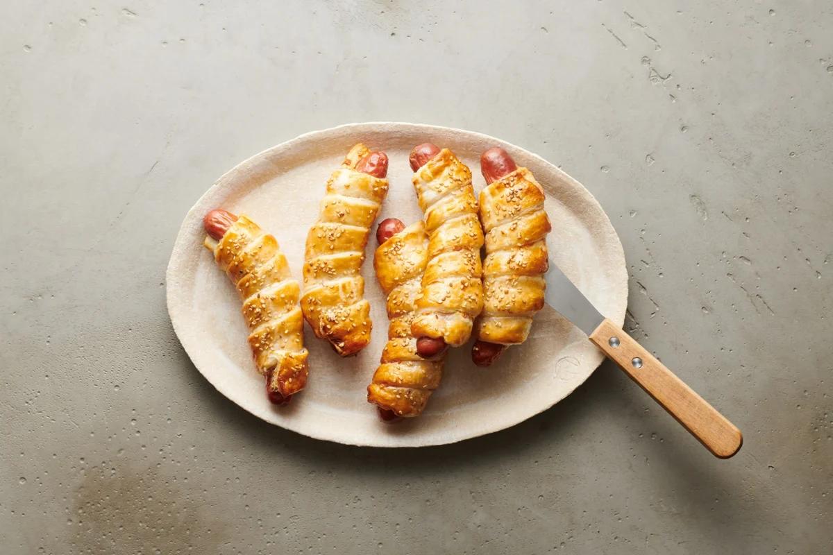 Wienerli im Teig aus der Kategorie Snacks &amp; Fingerfood. Das fertige Gericht schön angerichtet und fotografiert aus Vogelperspektive (Food Fotografie). Serviervorschlag, Original Tiptopf Rezept, aus dem bekanntesten Kochbuch der Schweiz