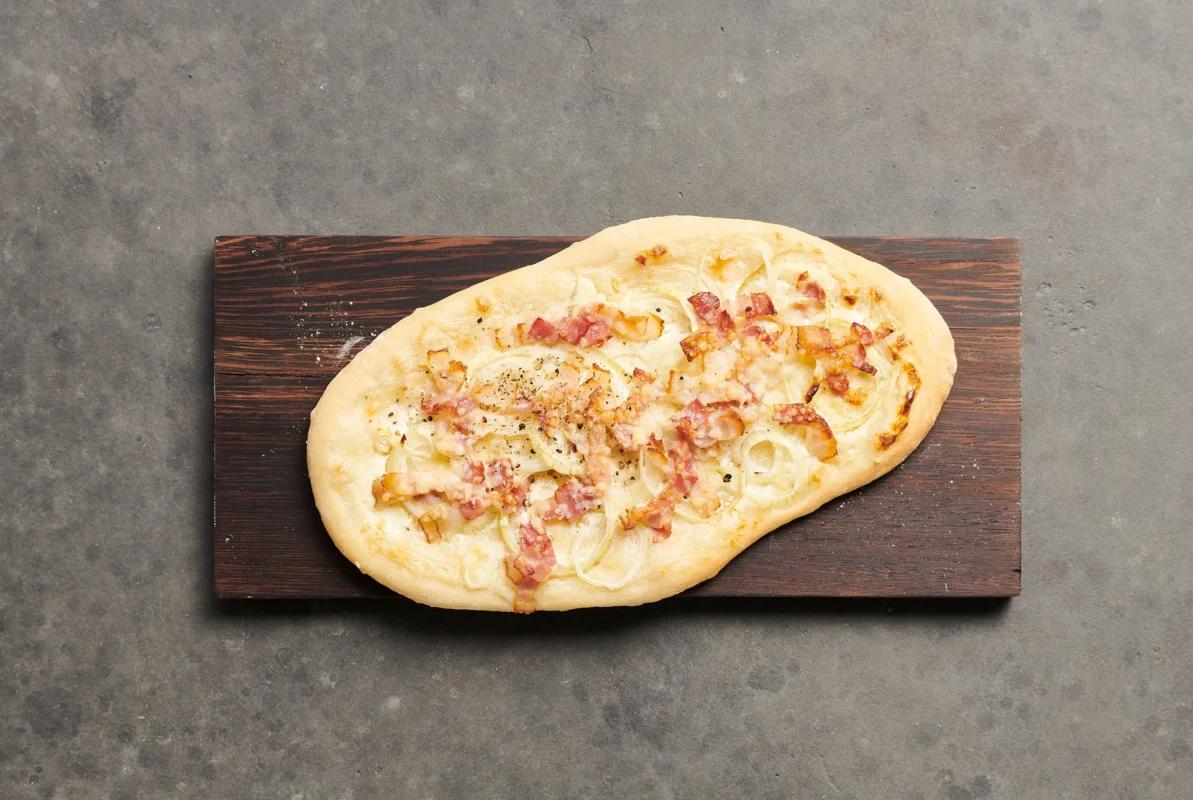 Flammkuchen aus der Kategorie Gebäck salzig. Das fertige Gericht schön angerichtet und fotografiert aus Vogelperspektive (Food Fotografie). Serviervorschlag, Original Tiptopf Rezept, aus dem bekanntesten Kochbuch der Schweiz