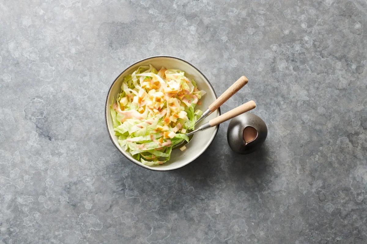 Eisbergsalat aus der Kategorie Salate. Zubereitungsmethode Rohkost. Das fertige Gericht schön angerichtet und fotografiert aus Vogelperspektive (Food Fotografie). Serviervorschlag, Original Tiptopf Rezept, aus dem bekanntesten Kochbuch der Schweiz