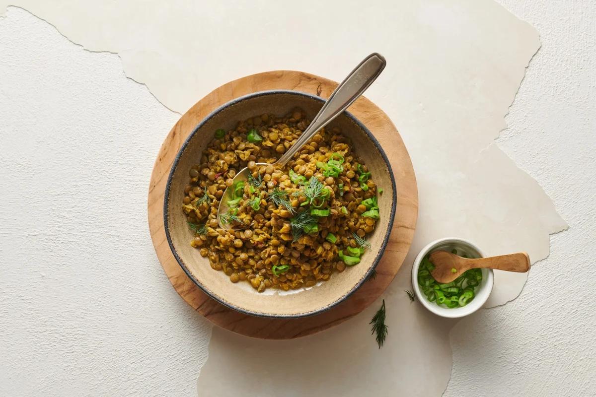 Safranlinsen aus der Kategorie Hülsenfrüchte &amp; Co. Zubereitungsmethode Dünsten. Das fertige Gericht schön angerichtet und fotografiert aus Vogelperspektive (Food Fotografie). Serviervorschlag, Original Tiptopf Rezept, aus dem bekanntesten Kochbuch der Schweiz