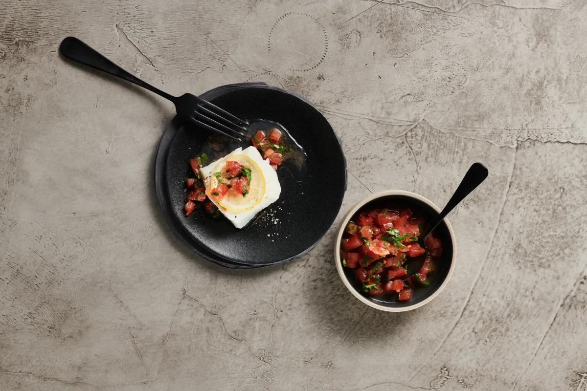 Fisch an Tomatensalsa. Das fertige Gericht schön angerichtet und fotografiert aus Vogelperspektive (Food Fotografie). Serviervorschlag, Original Tiptopf Rezept, aus dem bekanntesten Kochbuch der Schweiz