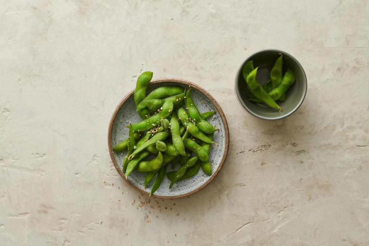 Edamame aus der Kategorie Snacks &amp; Fingerfood. Zubereitungsmethode Sieden. Das fertige Gericht schön angerichtet und fotografiert aus Vogelperspektive (Food Fotografie). Serviervorschlag, Original Tiptopf Rezept, aus dem bekanntesten Kochbuch der Schweiz