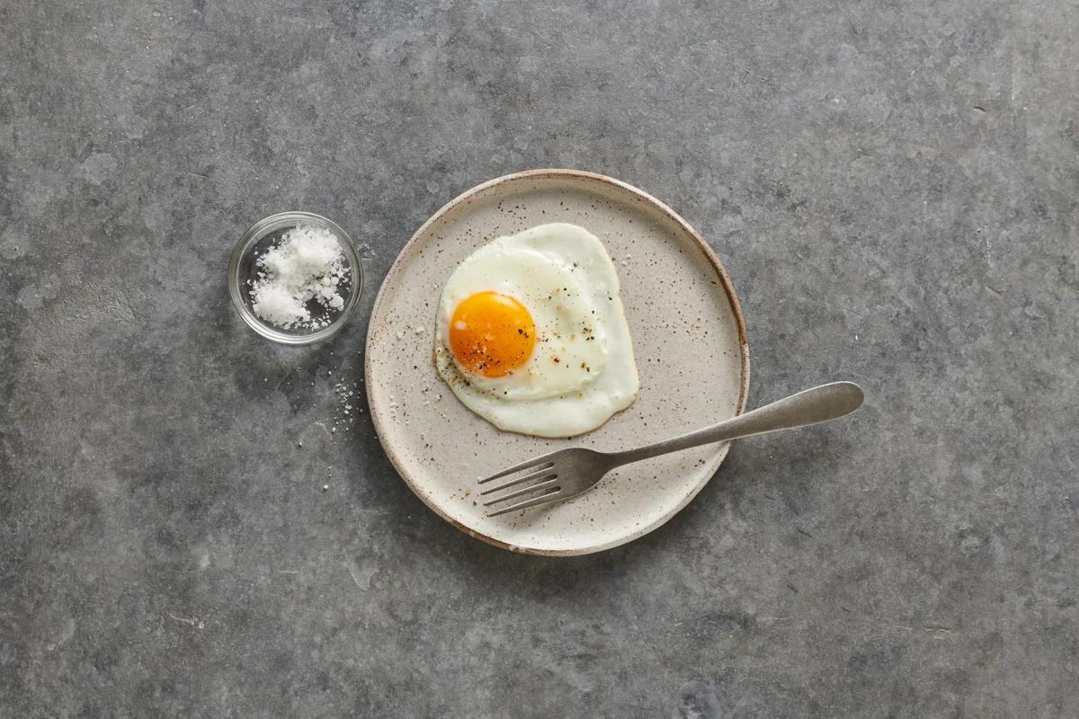 Spiegelei aus der Kategorie Frühstück &amp; Brunch. Zubereitungsmethode Braten. Das fertige Gericht schön angerichtet und fotografiert aus Vogelperspektive (Food Fotografie). Serviervorschlag, Original Tiptopf Rezept, aus dem bekanntesten Kochbuch der Schweiz