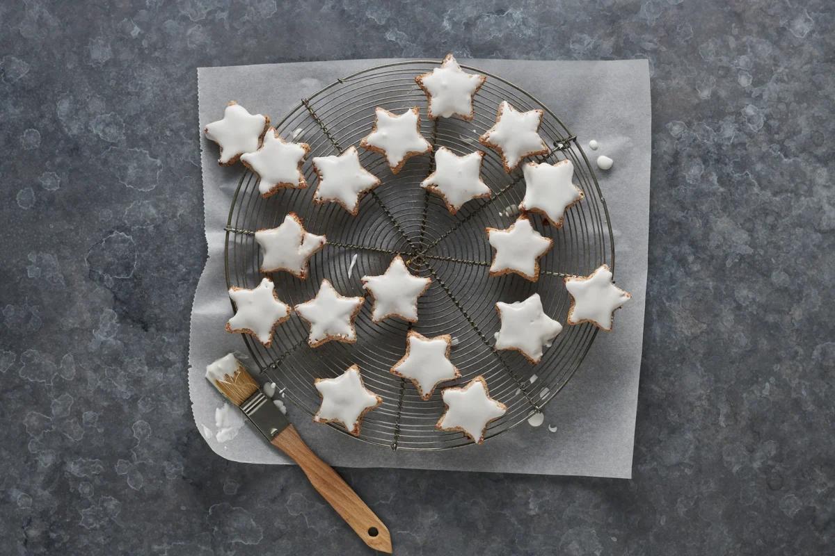 Zimtsterne aus der Kategorie Gebäck süss. Zubereitungsmethode Backen. Das fertige Gericht schön angerichtet und fotografiert aus Vogelperspektive (Food Fotografie). Serviervorschlag, Original Tiptopf Rezept, aus dem bekanntesten Kochbuch der Schweiz