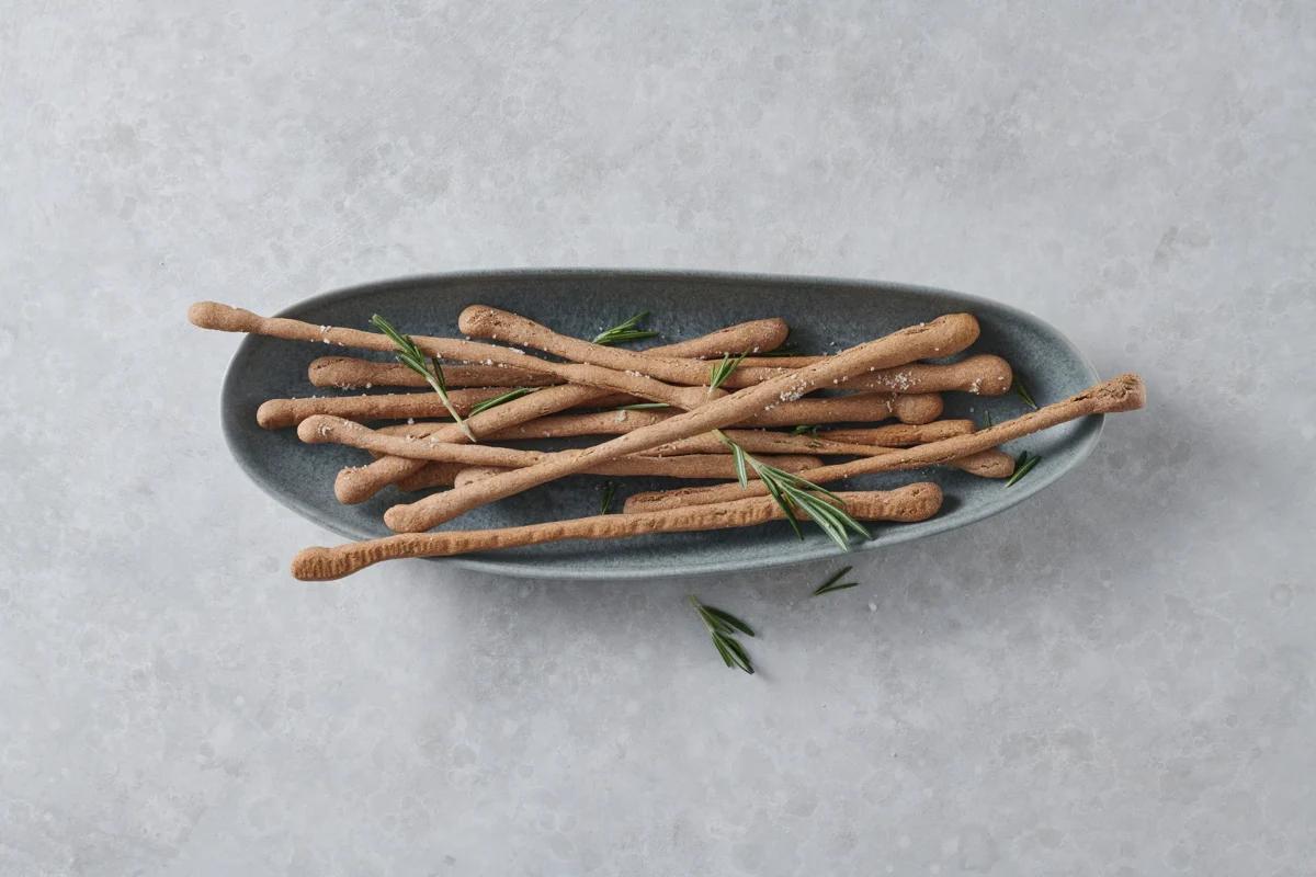 Grissini aus der Kategorie Snacks &amp; Fingerfood. Zubereitungsmethode Backen. Das fertige Gericht schön angerichtet und fotografiert aus Vogelperspektive (Food Fotografie). Serviervorschlag, Original Tiptopf Rezept, aus dem bekanntesten Kochbuch der Schweiz