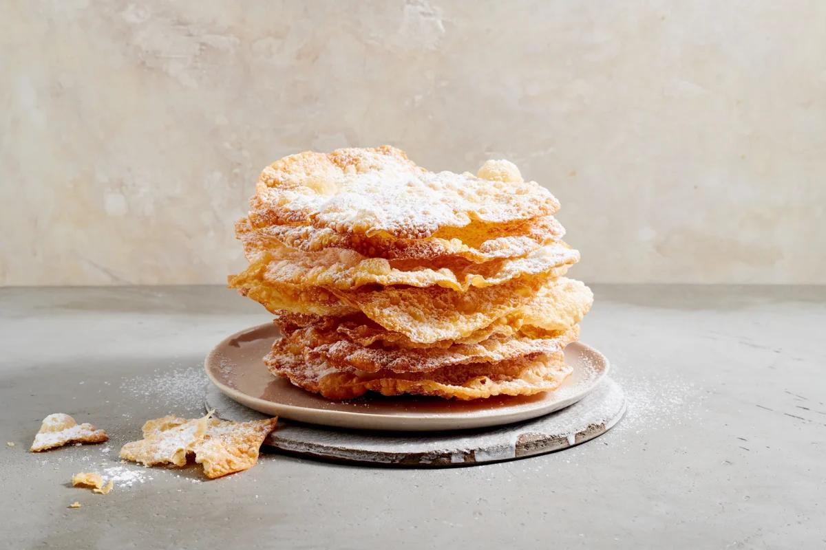 Fasnachtschüechli aus der Kategorie Gebäck süss. Zubereitungsmethode Frittieren. Das fertige Gericht schön angerichtet und fotografiert aus Vogelperspektive (Food Fotografie). Serviervorschlag, Original Tiptopf Rezept, aus dem bekanntesten Kochbuch der Schweiz