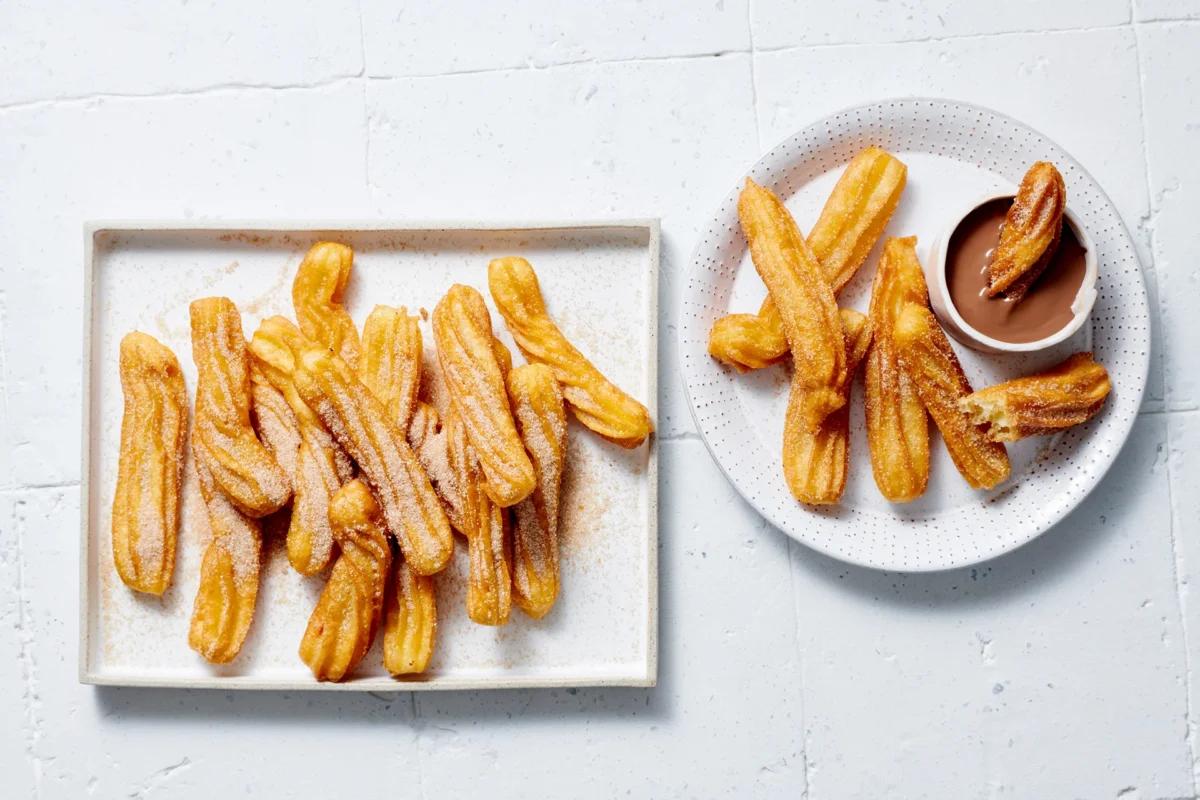 Churros. Das fertige Gericht schön angerichtet und fotografiert aus Vogelperspektive (Food Fotografie). Serviervorschlag, Original Tiptopf Rezept, aus dem bekanntesten Kochbuch der Schweiz