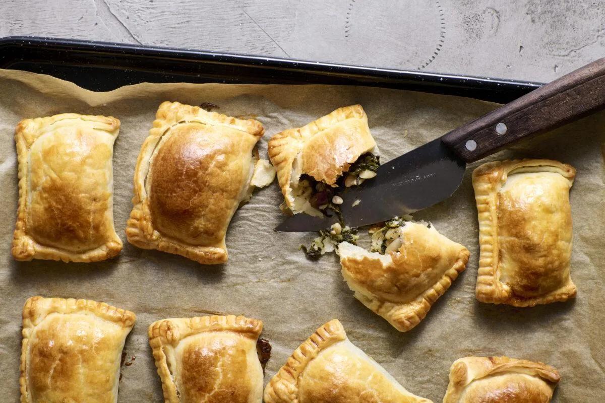 Hüttenkäse-Spinat-Empanadas aus der Kategorie Gebäck salzig. Das fertige Gericht schön angerichtet und fotografiert aus Vogelperspektive (Food Fotografie). Serviervorschlag, Original Tiptopf Rezept, aus dem bekanntesten Kochbuch der Schweiz