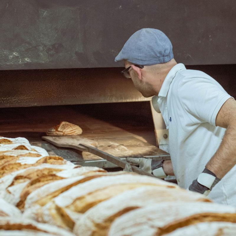 Mann in der Backstube beim Brotbacken