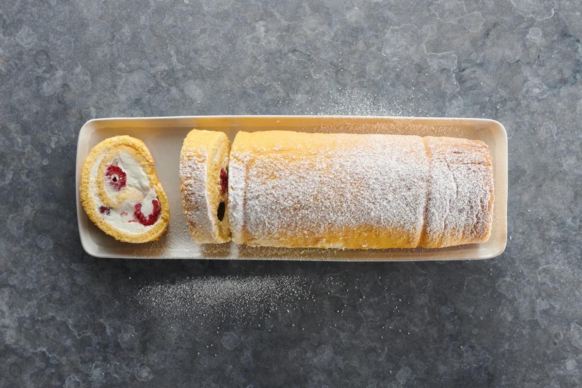 Biskuitroulade mit Früchten aus der Kategorie Gebäck süss. Das fertige Gericht schön angerichtet und fotografiert aus Vogelperspektive (Food Fotografie). Serviervorschlag, Original Tiptopf Rezept, aus dem bekanntesten Kochbuch der Schweiz