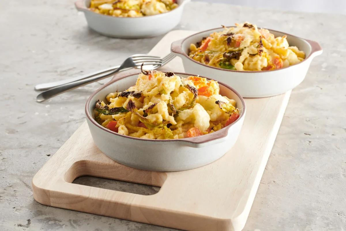 Knöpfligratin, aus der Kategorie . Zubereitungsmethode Angerührter Teig. Das fertige Gericht schön angerichtet und fotografiert aus Vogelperspektive (Food Fotografie). Serviervorschlag, Original Tiptopf Rezept, aus dem bekanntesten Kochbuch der Schweiz