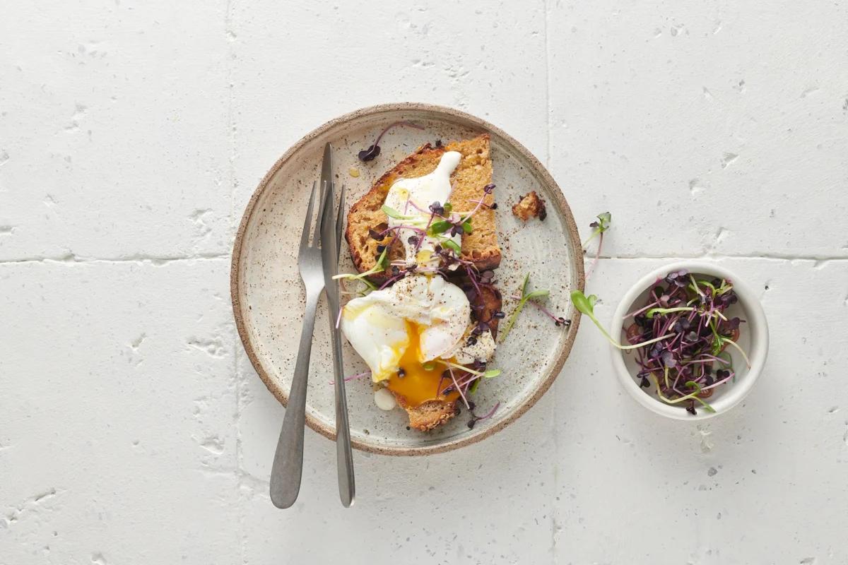 Pochierte Eier auf Toast aus der Kategorie Frühstück & Brunch. Das fertige Gericht schön angerichtet und fotografiert aus Vogelperspektive (Food Fotografie). Serviervorschlag, Original Tiptopf Rezept, aus dem bekanntesten Kochbuch der Schweiz