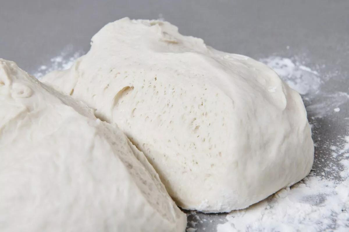 Pizzateig, aus der Kategorie . Zubereitungsmethode Backen. Das fertige Gericht schön angerichtet und fotografiert aus Vogelperspektive (Food Fotografie). Serviervorschlag, Original Tiptopf Rezept, aus dem bekanntesten Kochbuch der Schweiz